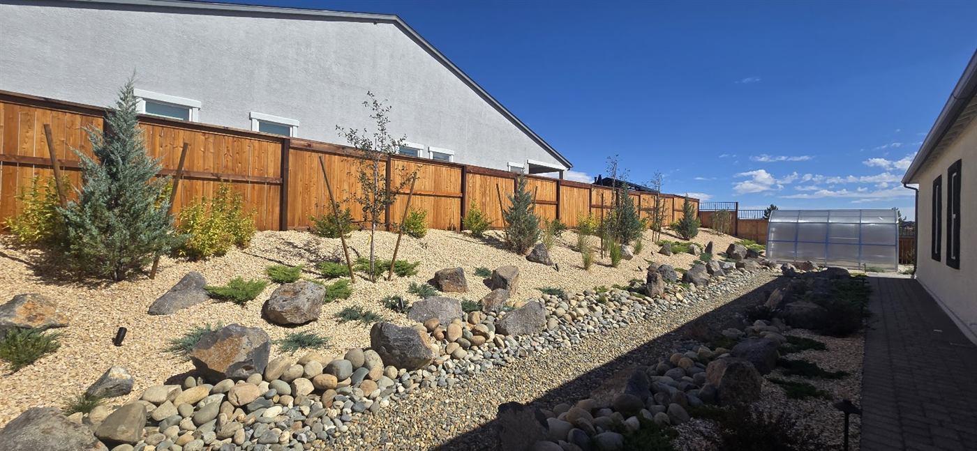 Freshly stained wood fence along a landscaped hillside backyard in Reno